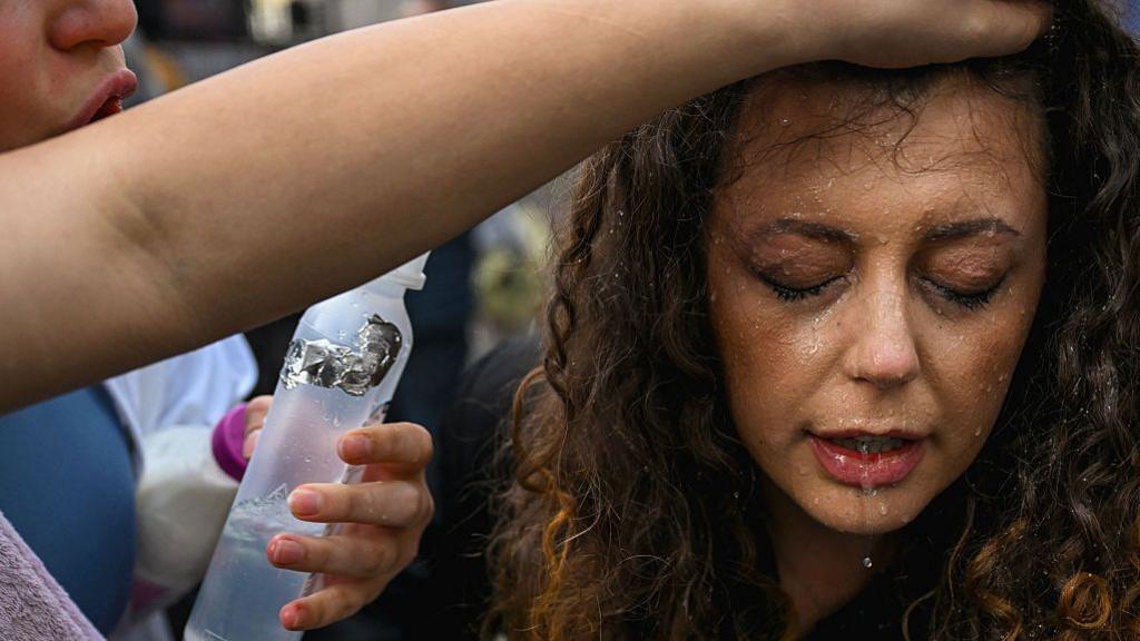 Protester cleaning tear gas from a fellow activist