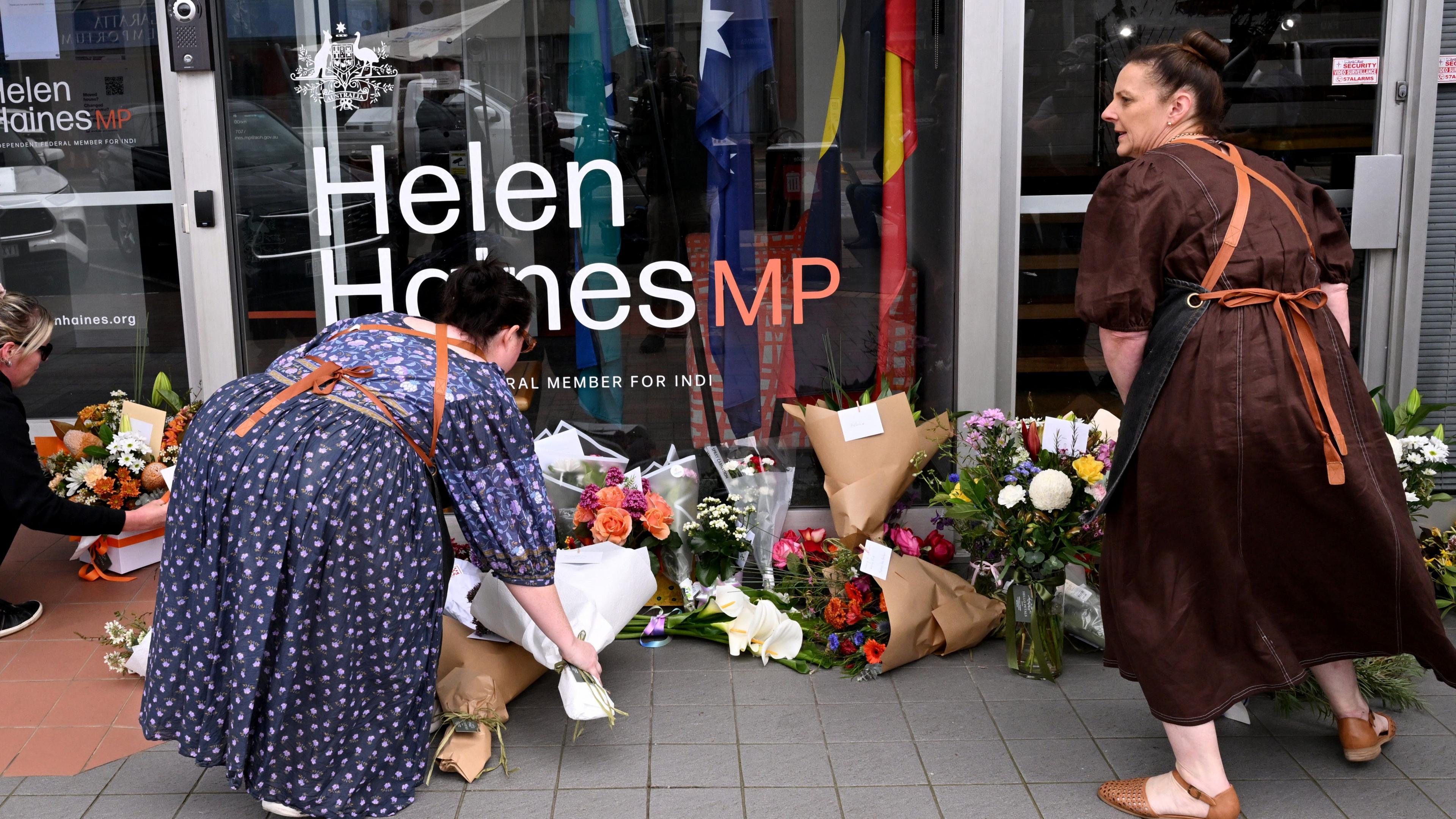Women leaving flowers outside Helen Haines