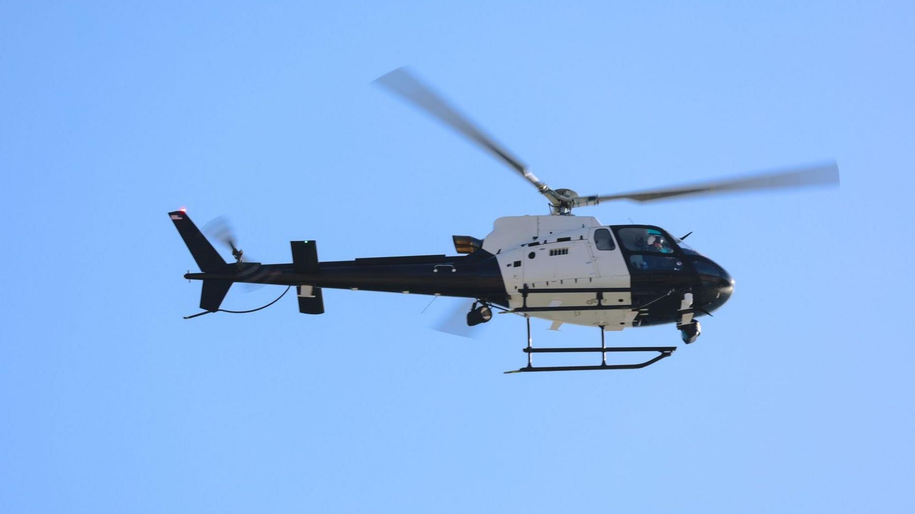 Black and white helicopter near crash site