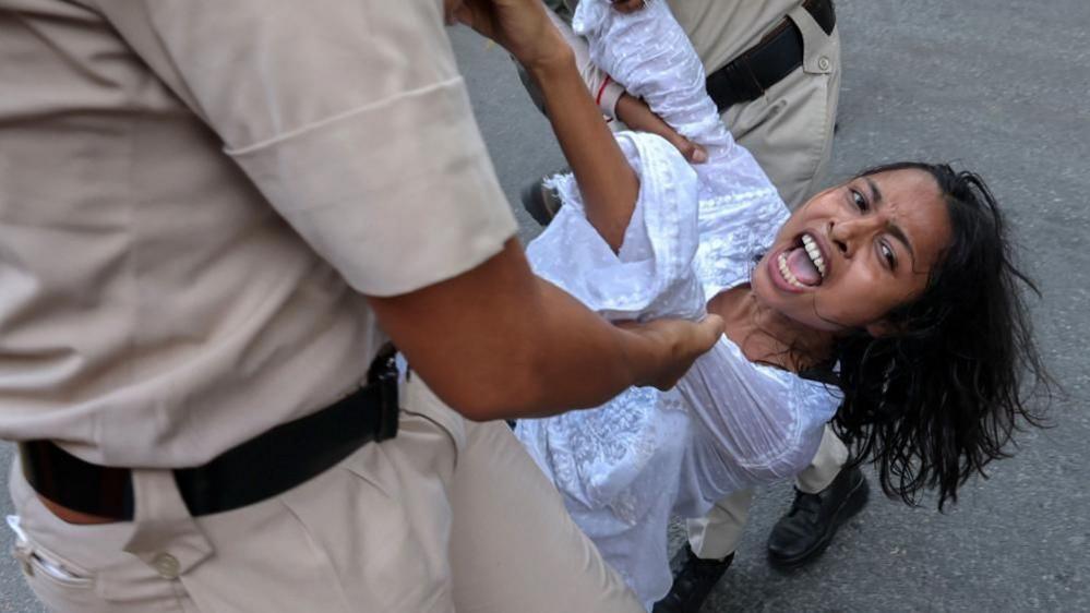 Police dragging a female protestor