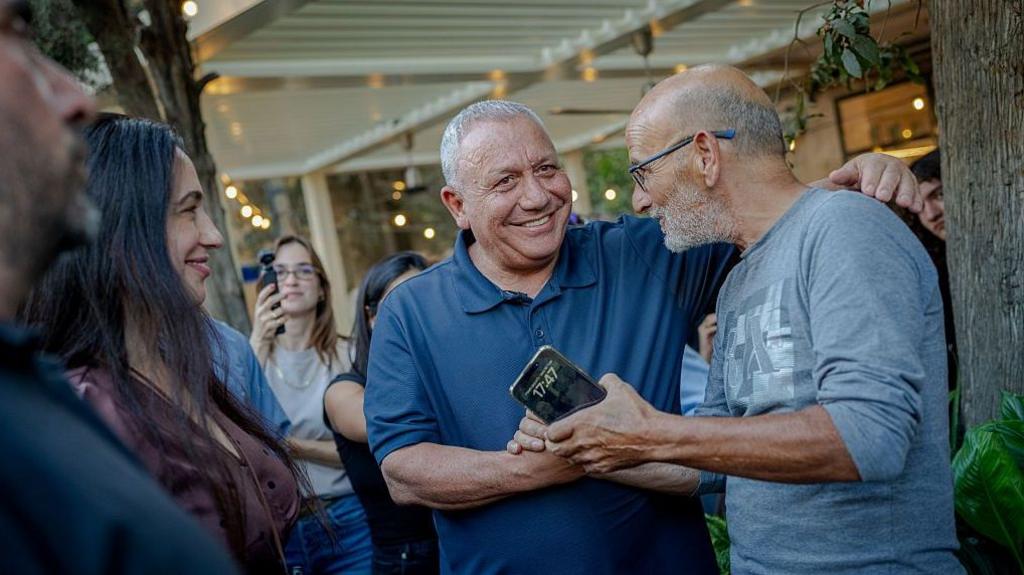 Eisenkot shakes a hand with a local resident