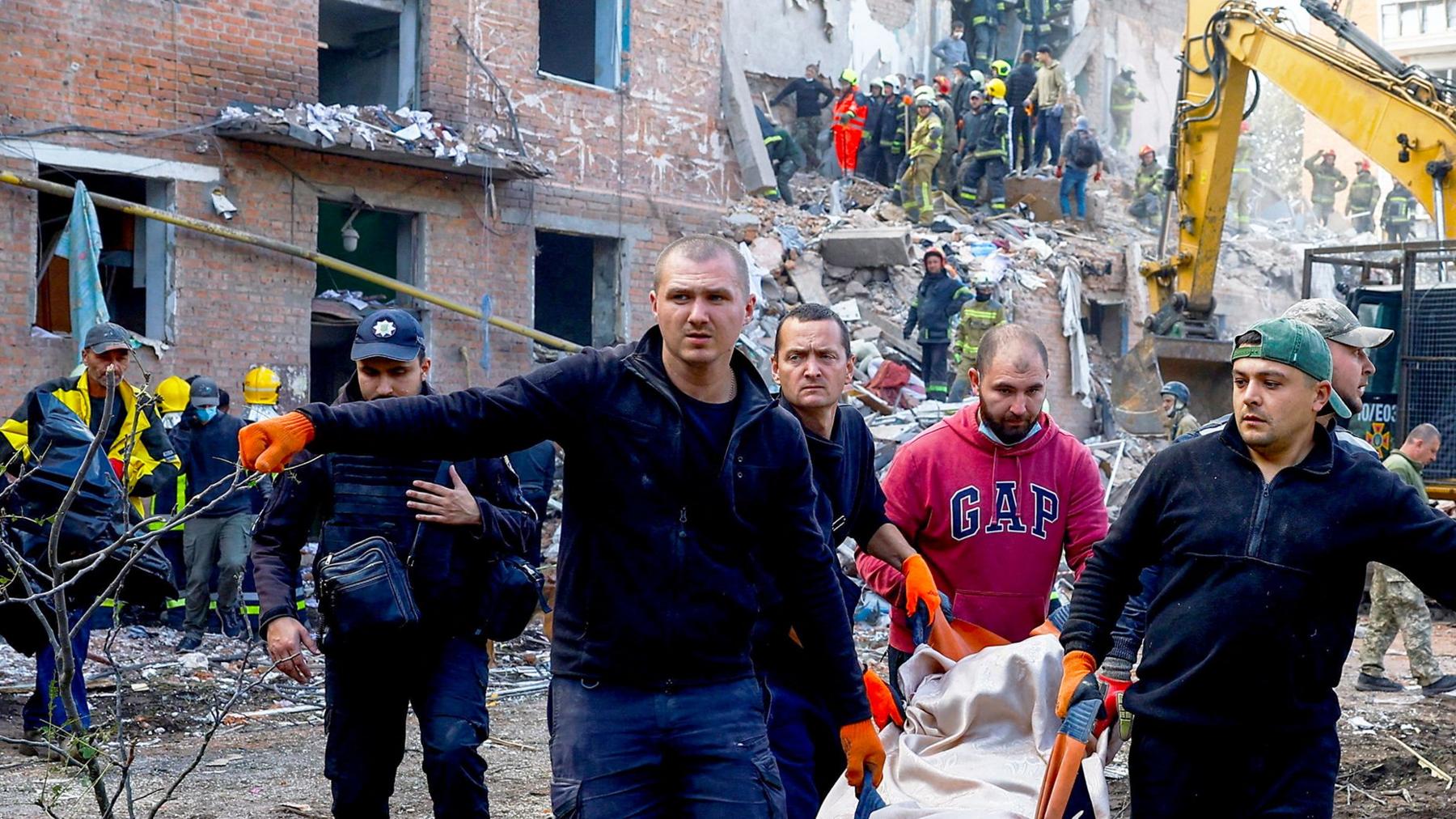 People carry casualty from apartment building blast